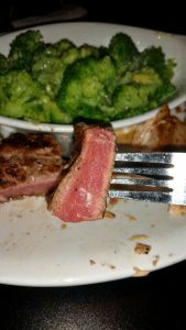 A properly cooked piece of steak: brown on the outside and dark reddish pink on the inside.
